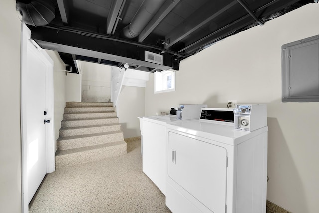 clothes washing area featuring electric panel and washer and clothes dryer