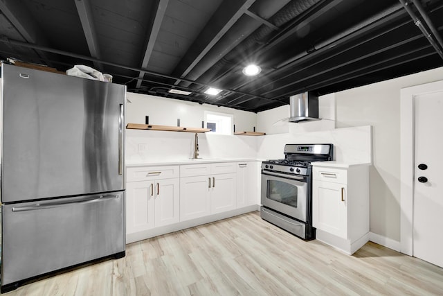 kitchen with wall chimney exhaust hood, light hardwood / wood-style floors, white cabinetry, and appliances with stainless steel finishes