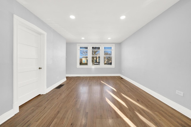 empty room with dark hardwood / wood-style flooring