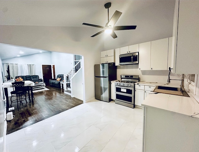 kitchen with white cabinetry, ceiling fan, lofted ceiling, appliances with stainless steel finishes, and light wood-type flooring