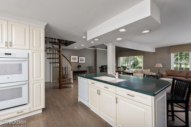 kitchen featuring white appliances, a kitchen island with sink, sink, dark hardwood / wood-style floors, and white cabinetry