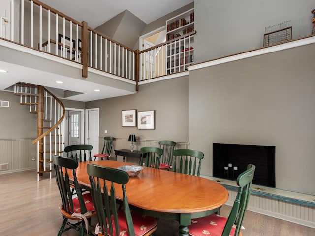 dining space with a high ceiling and light hardwood / wood-style floors