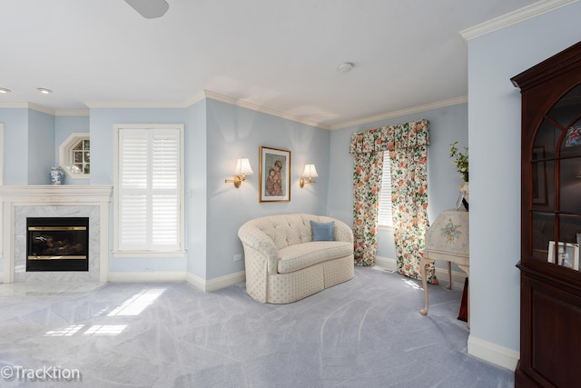 living area with light colored carpet, crown molding, and a high end fireplace