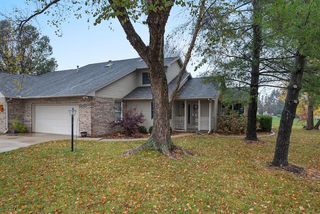 view of front of home with covered porch, a garage, and a front yard