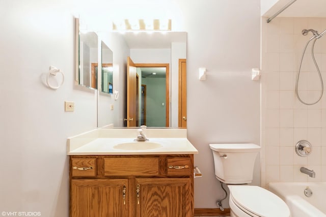 full bathroom featuring vanity, tiled shower / bath combo, and toilet