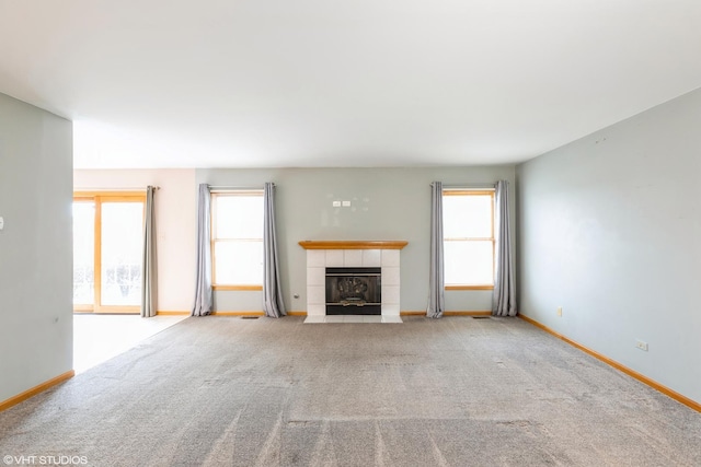 unfurnished living room with light carpet and a tile fireplace