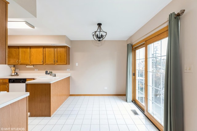 kitchen featuring dishwasher, sink, kitchen peninsula, a chandelier, and decorative light fixtures