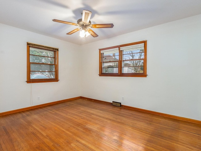 empty room with ceiling fan and light hardwood / wood-style floors