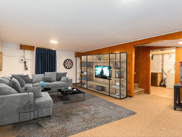 living room featuring washer / clothes dryer, wood walls, and carpet