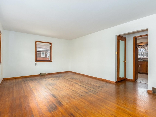 unfurnished room with sink and hardwood / wood-style flooring