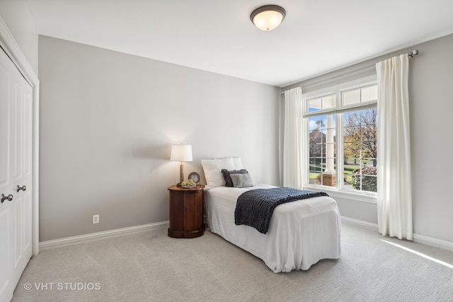 bedroom featuring light colored carpet and a closet