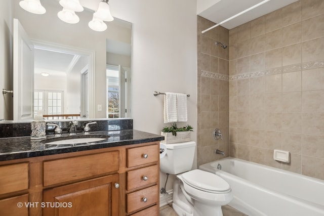 full bathroom featuring vanity, tiled shower / bath combo, toilet, and ornamental molding