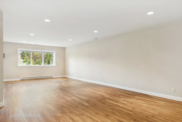 unfurnished room with light hardwood / wood-style floors and baseboard heating