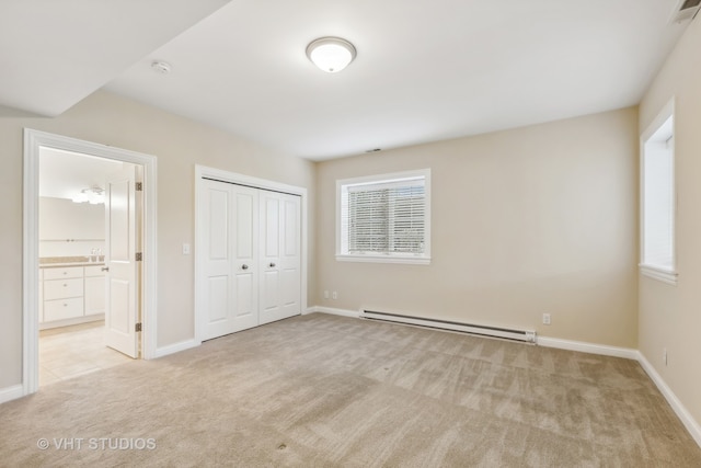 unfurnished bedroom featuring ensuite bathroom, a closet, light colored carpet, and a baseboard radiator