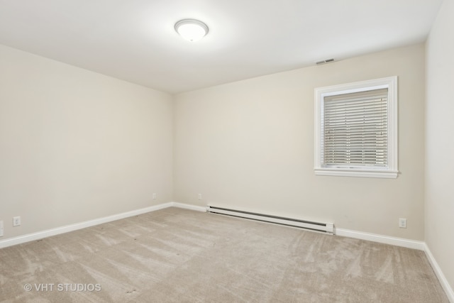 empty room featuring light colored carpet and baseboard heating