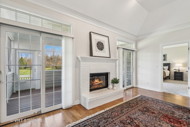 unfurnished living room featuring hardwood / wood-style flooring, crown molding, lofted ceiling, and a fireplace