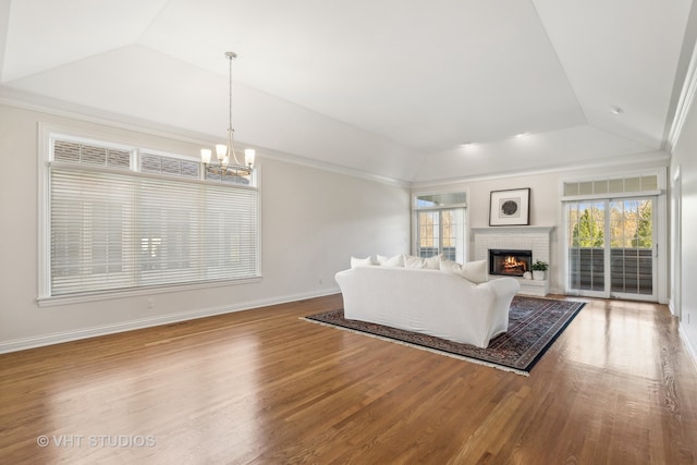 living room featuring hardwood / wood-style floors, lofted ceiling, and a notable chandelier