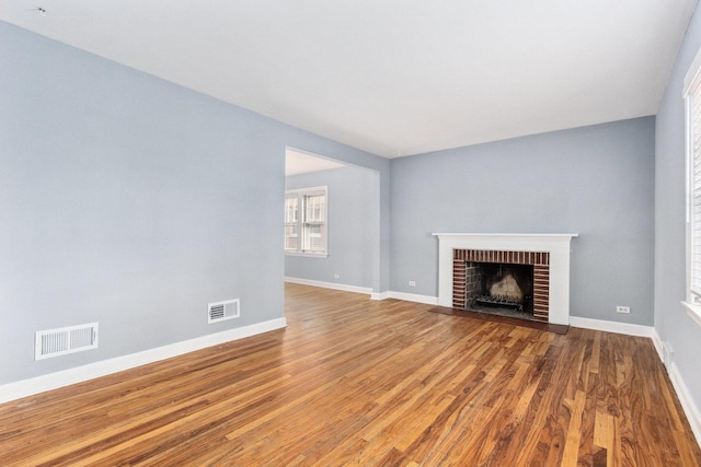 unfurnished living room featuring wood-type flooring and a fireplace