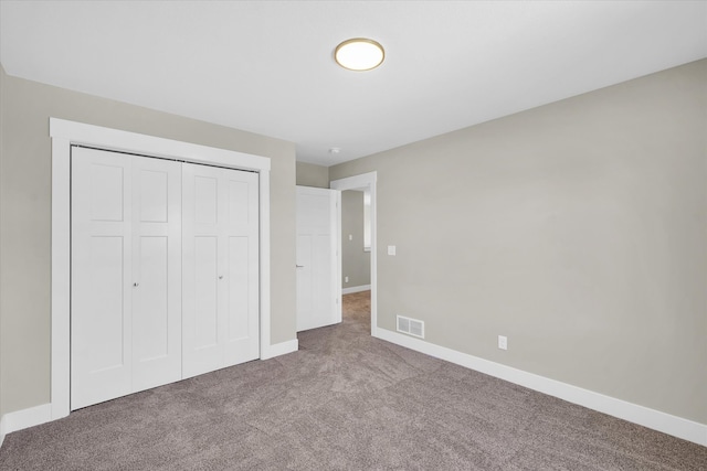 unfurnished bedroom featuring carpet flooring and a closet