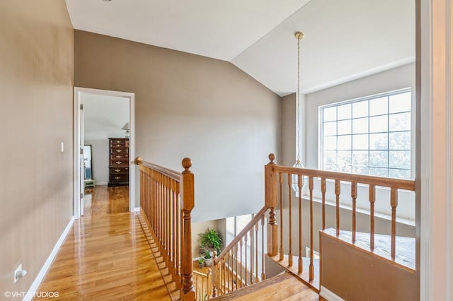 hallway featuring vaulted ceiling and light wood-type flooring