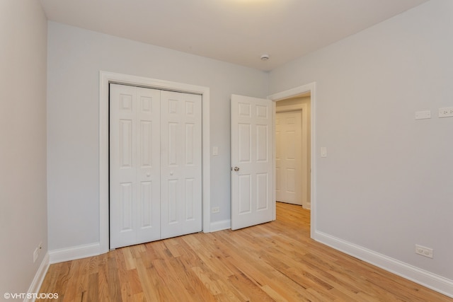 unfurnished bedroom featuring light hardwood / wood-style floors and a closet