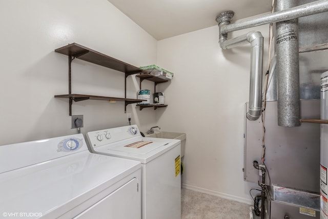 laundry area with separate washer and dryer and light colored carpet