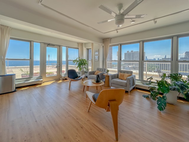 sunroom / solarium with ceiling fan, a healthy amount of sunlight, and a water view