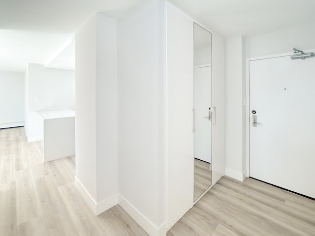 corridor featuring light hardwood / wood-style flooring and baseboard heating