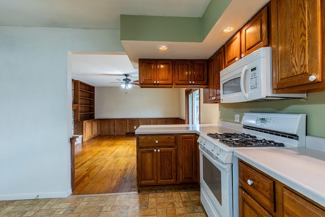 kitchen with kitchen peninsula, ceiling fan, and white appliances