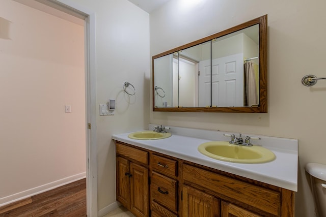 bathroom with vanity, hardwood / wood-style flooring, and toilet