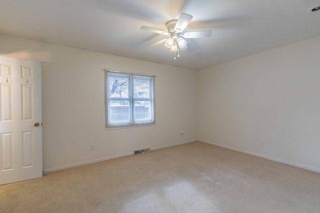 spare room featuring ceiling fan and light carpet