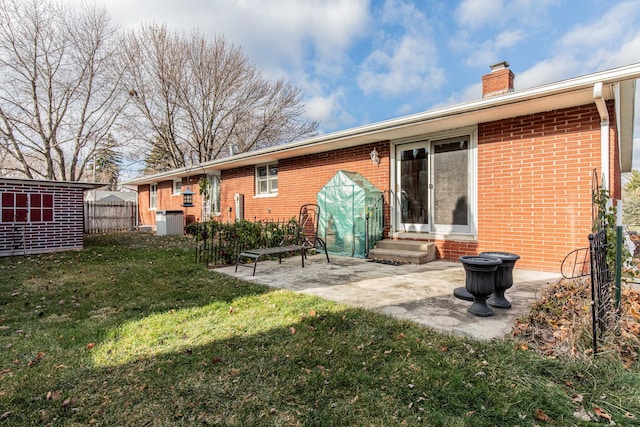 back of property with cooling unit, a patio area, and a yard