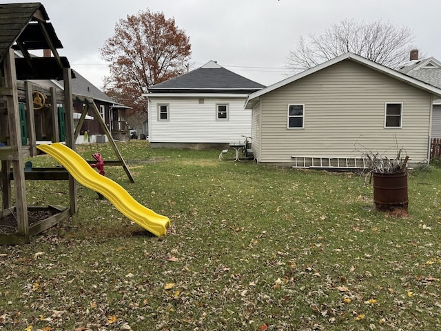 back of house featuring a playground and a lawn