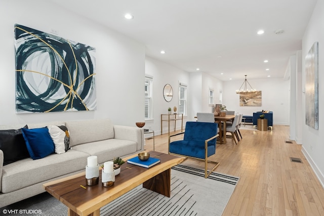 living room featuring a chandelier and light hardwood / wood-style flooring