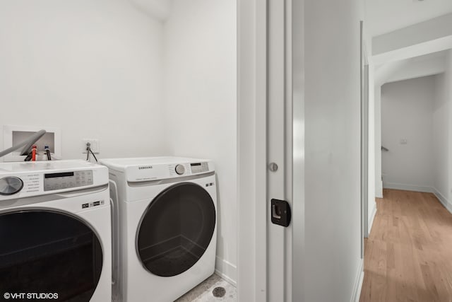 washroom with washing machine and dryer and light wood-type flooring