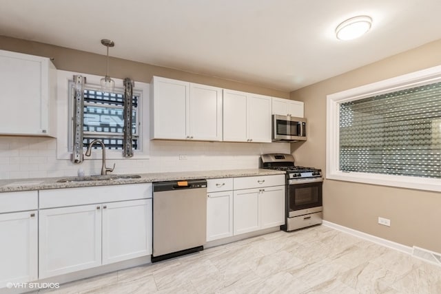 kitchen featuring stainless steel appliances, white cabinetry, and sink