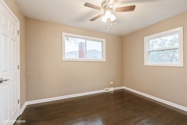 unfurnished room with ceiling fan and dark wood-type flooring