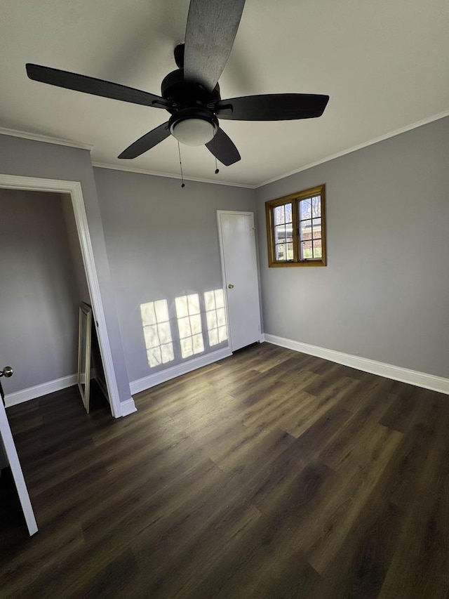 empty room featuring ceiling fan, ornamental molding, and dark wood-type flooring