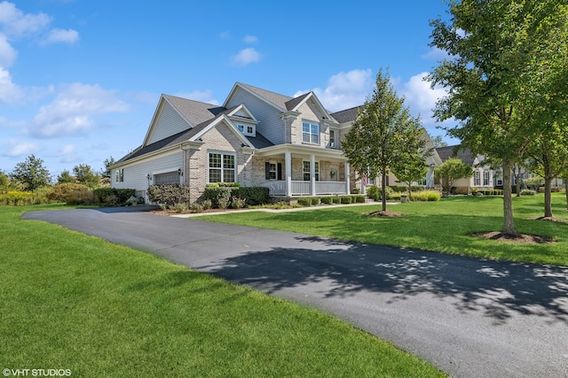 view of front of property with a garage, covered porch, and a front lawn