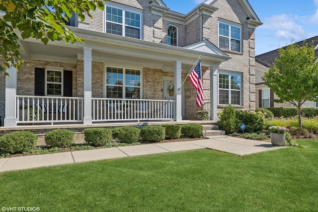 view of front of property featuring covered porch and a front yard