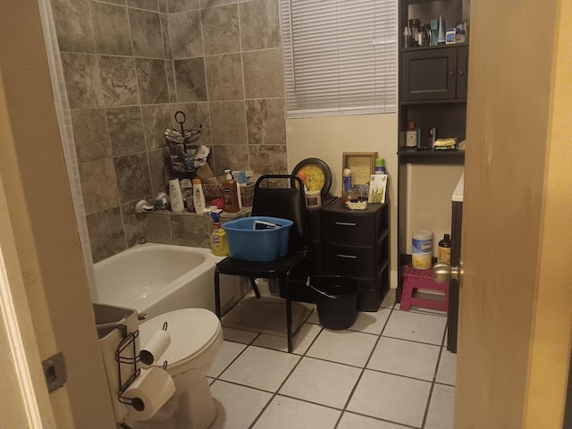 bathroom with tile patterned flooring, toilet, and a tub to relax in