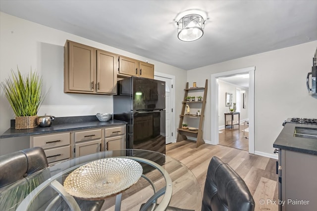 kitchen with black fridge and light hardwood / wood-style flooring