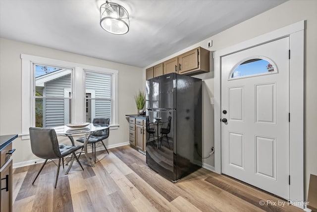 kitchen featuring light wood-type flooring and black fridge