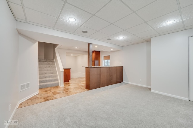 bar featuring a paneled ceiling and light carpet