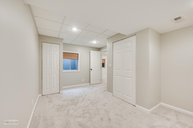 carpeted spare room with a drop ceiling