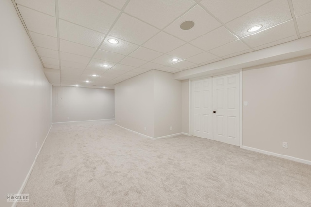 basement featuring carpet flooring and a drop ceiling