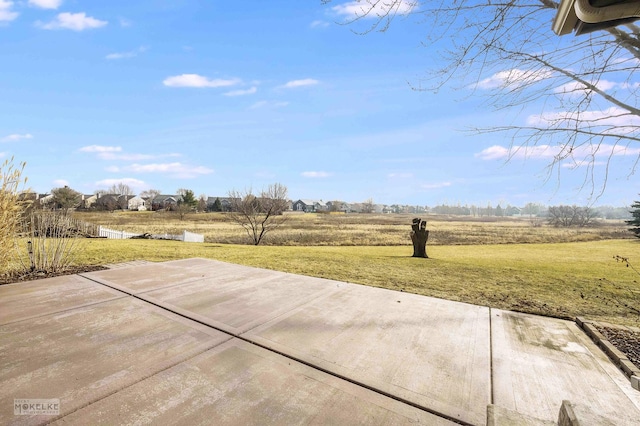 view of yard with a rural view and a patio