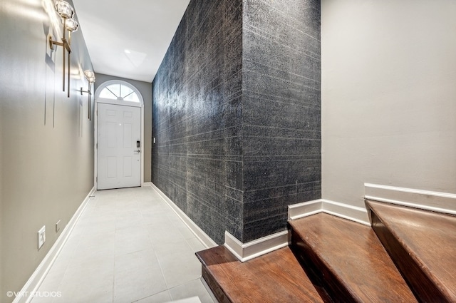 doorway featuring tile patterned floors and tile walls