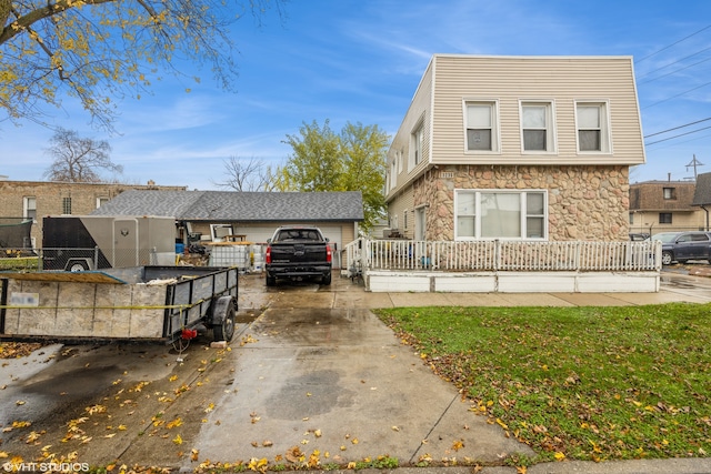 view of front of home with a front lawn, an outdoor structure, and a garage