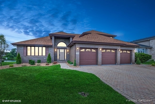 prairie-style home with a yard and a garage